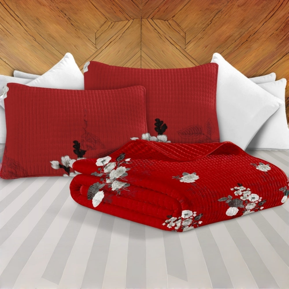 Detalle del cubrecama acolchado y las fundas de almohada a juego en rojo y blanco